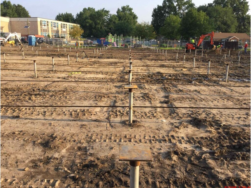 Job site showing helicals embedded in ground in a grid