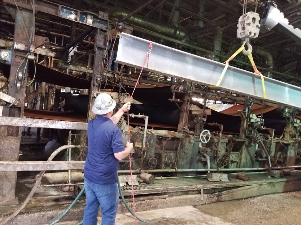 Worker maneuvers steel beam as part of Cincinnati Paperboard repairs
